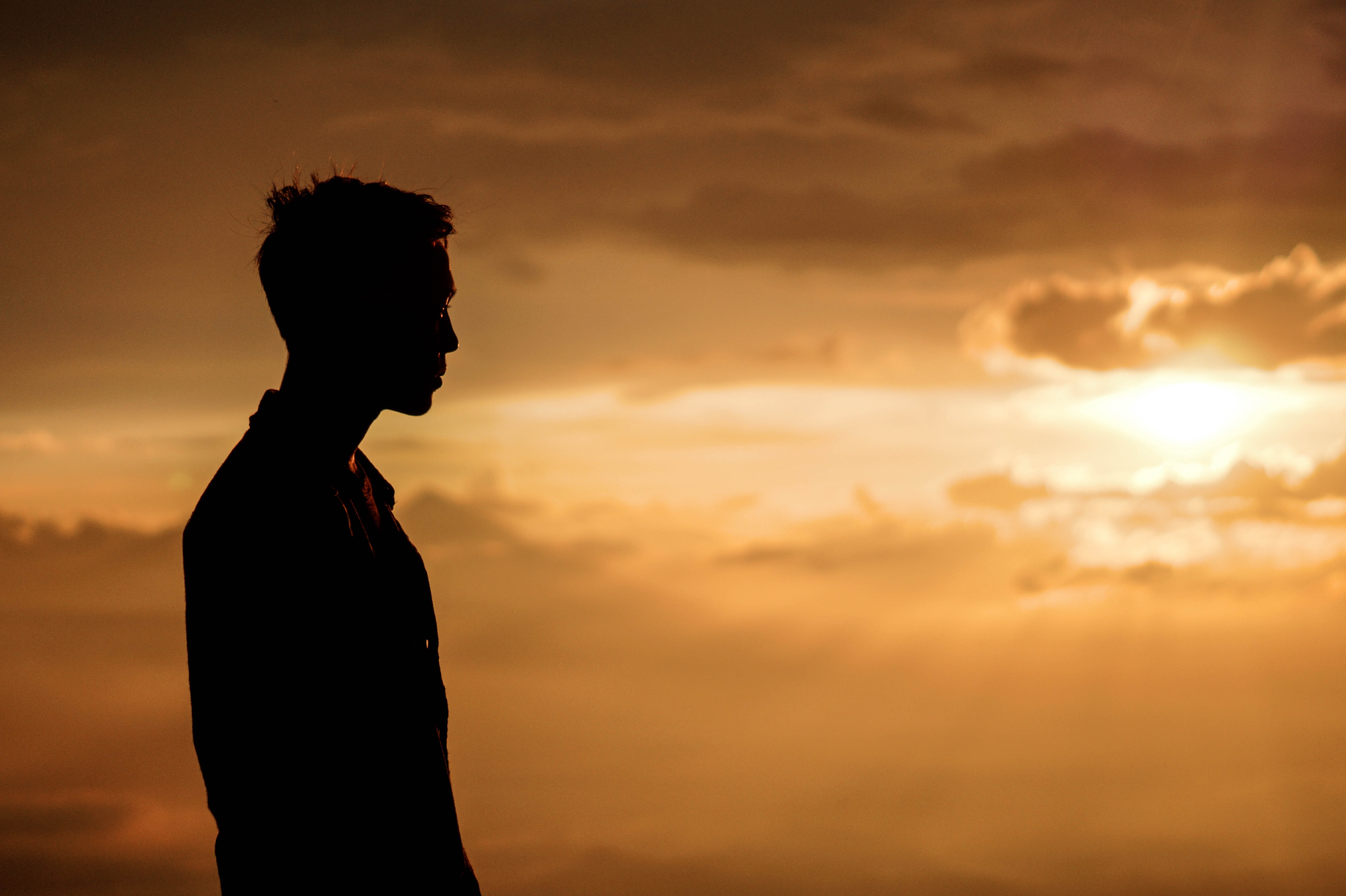 A man contemplates during a sunset.