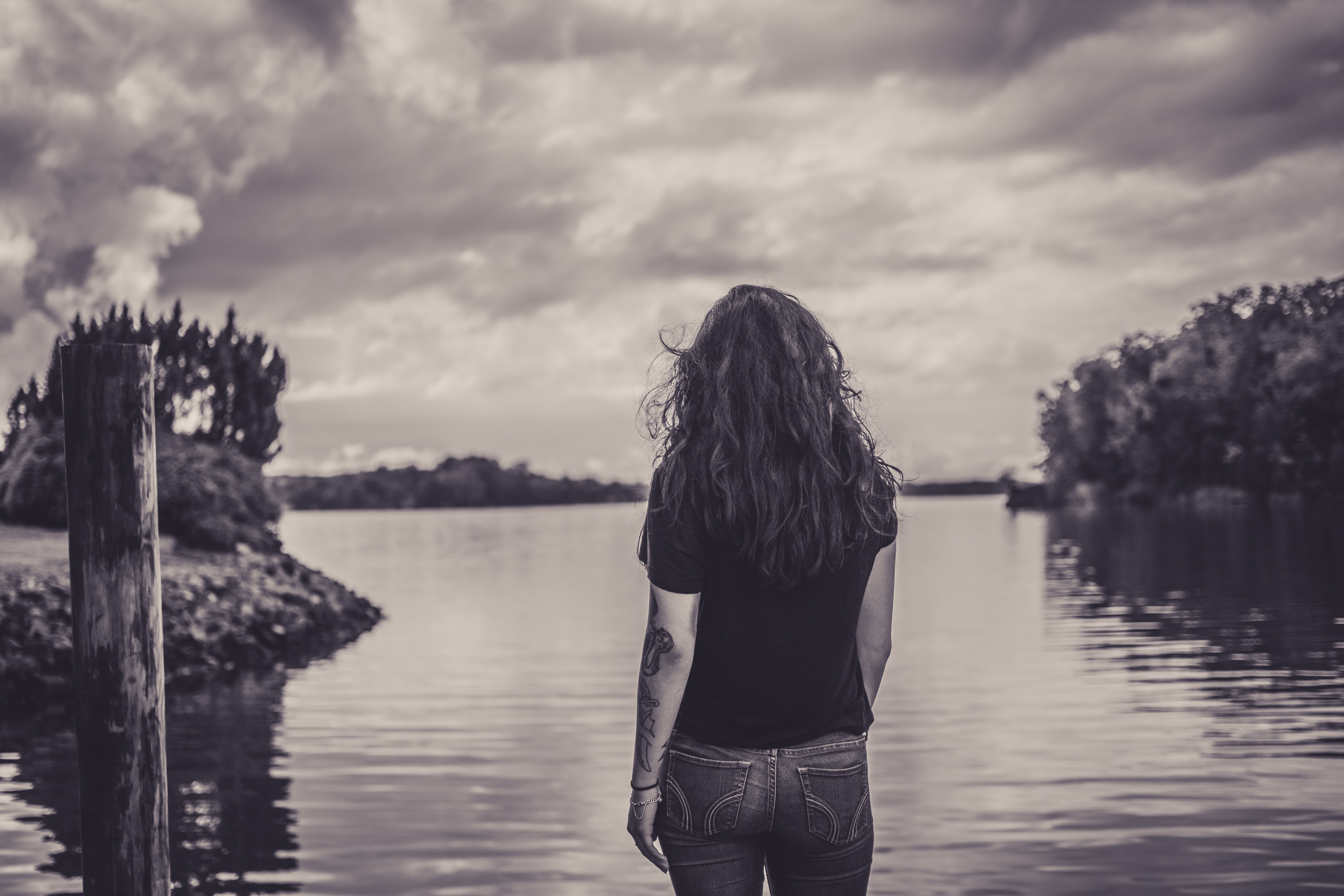 Photo of woman looking out onto a body of water by Brittani Burns