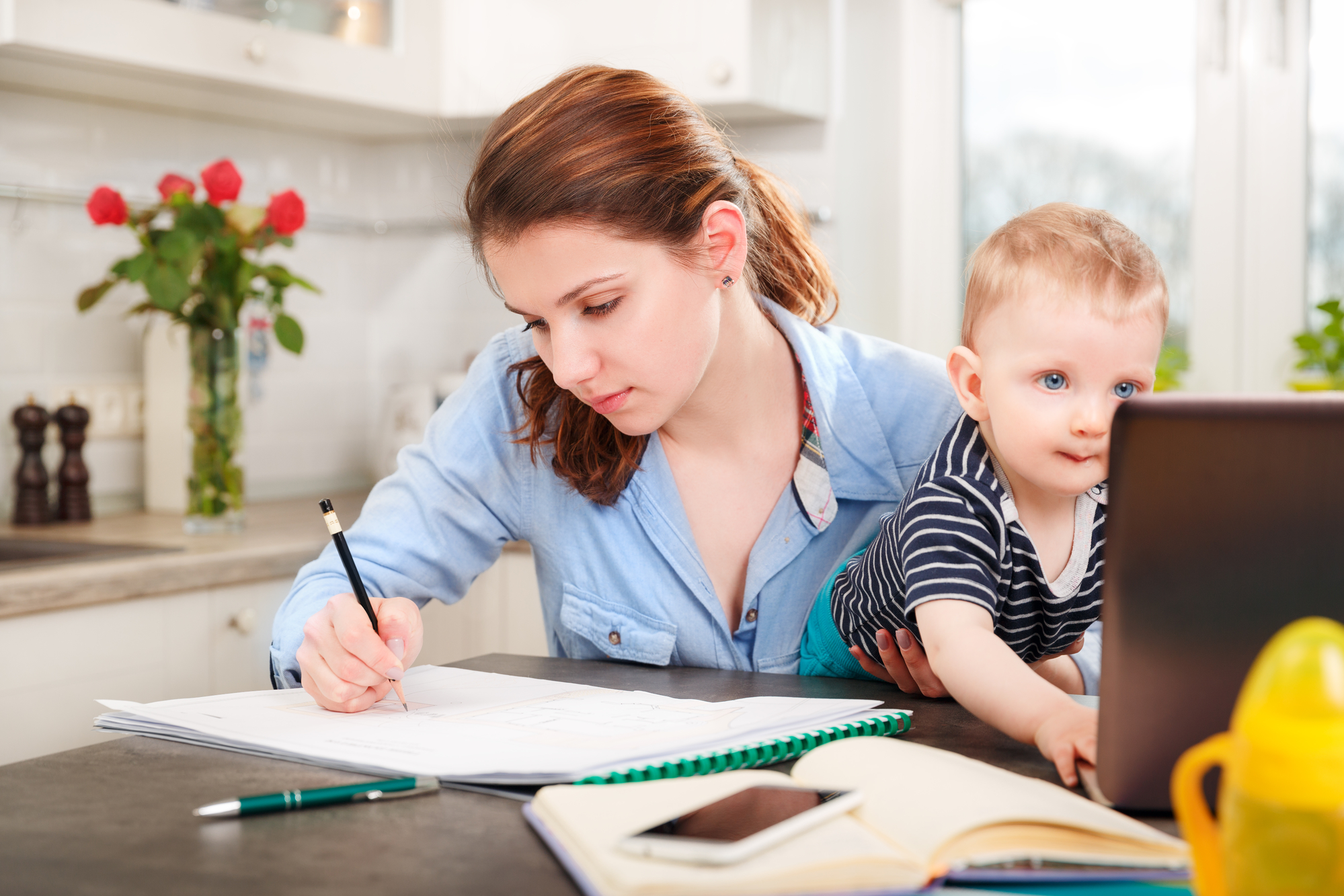mother studying with child on lap