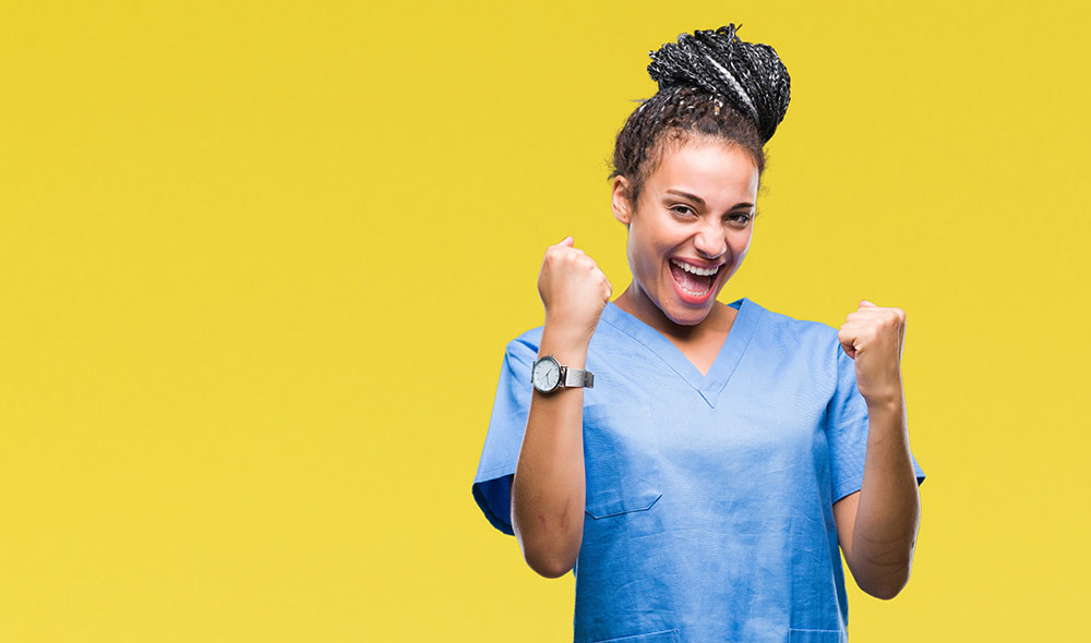 Young braided hair african american girl professional nurse over isolated background very happy and excited doing winner gesture with arms raised, smiling and screaming for success. Celebration concept.