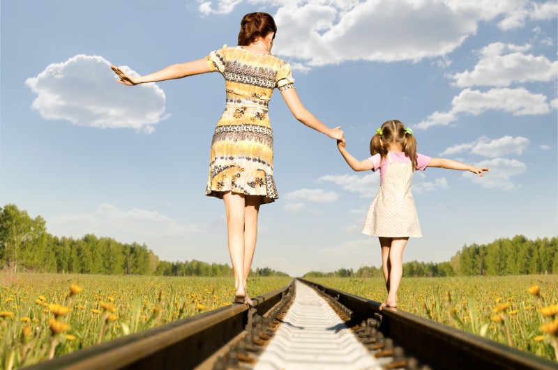 mother adn child walking along train tracks