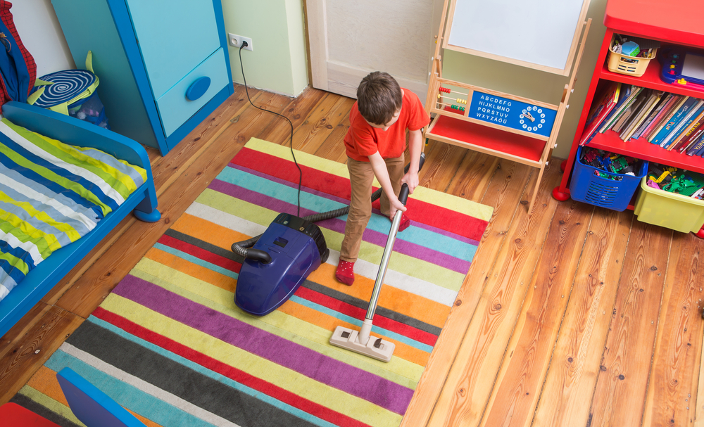 child vacuuming his room