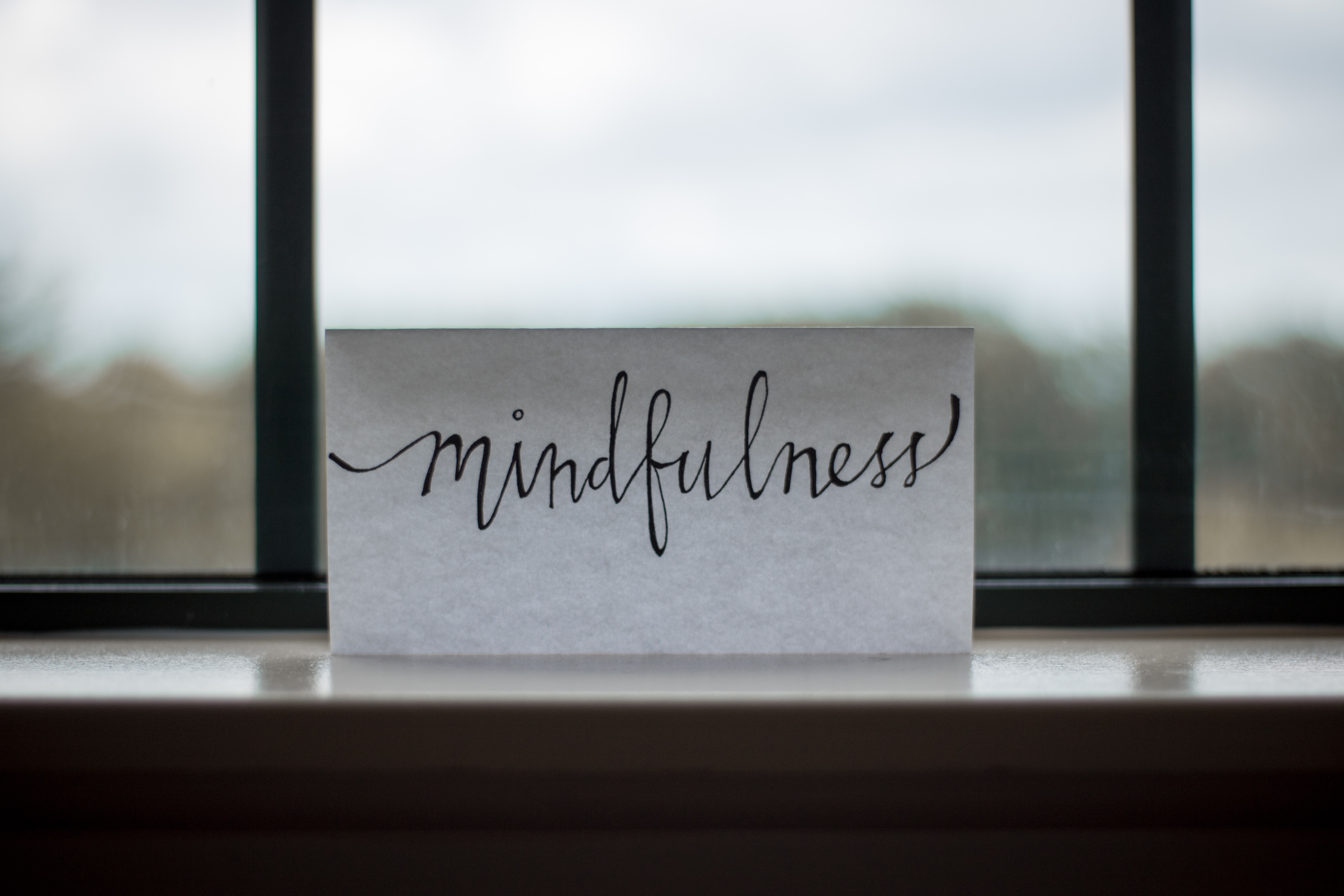 "Mindfulness" wrritten on white paper, standing on the window ledge