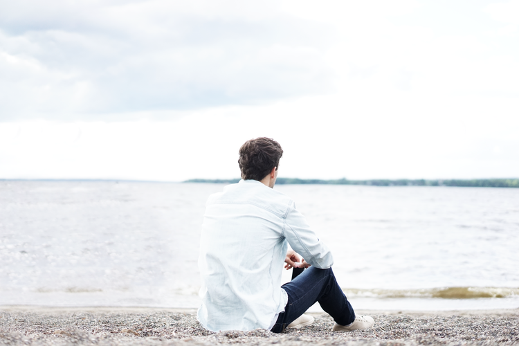 A man sitting and thinking in front of a bay