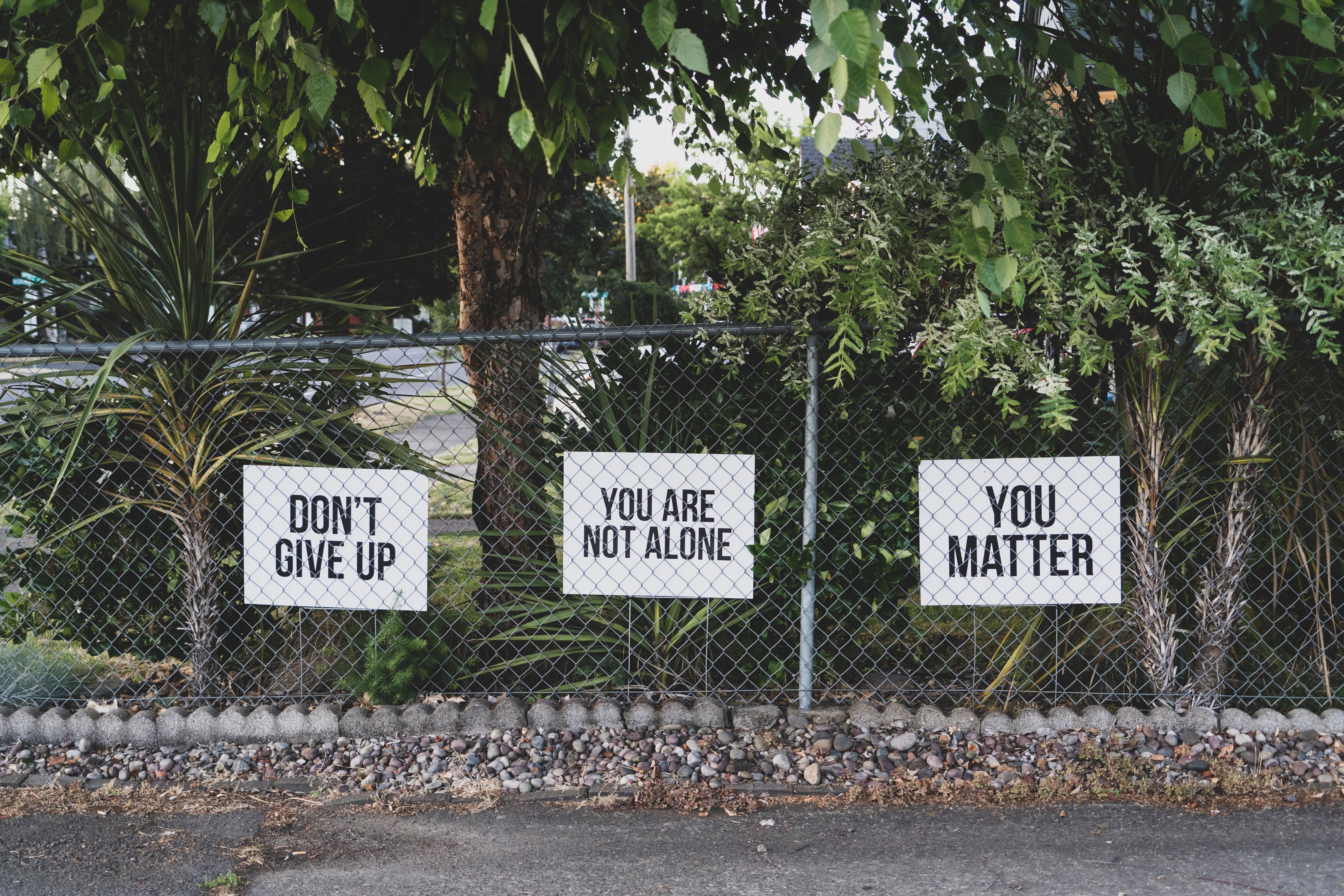 Motivational and Supportive Messages Attached To A Chain-link Fence. "Don't give up" You are not alone" You matter"