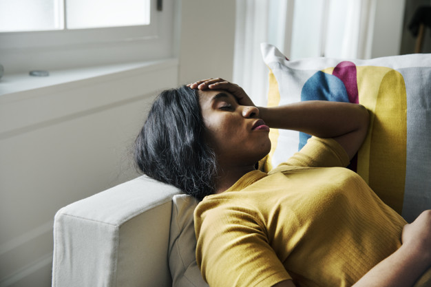Women on sofa with headache due to sleep loss