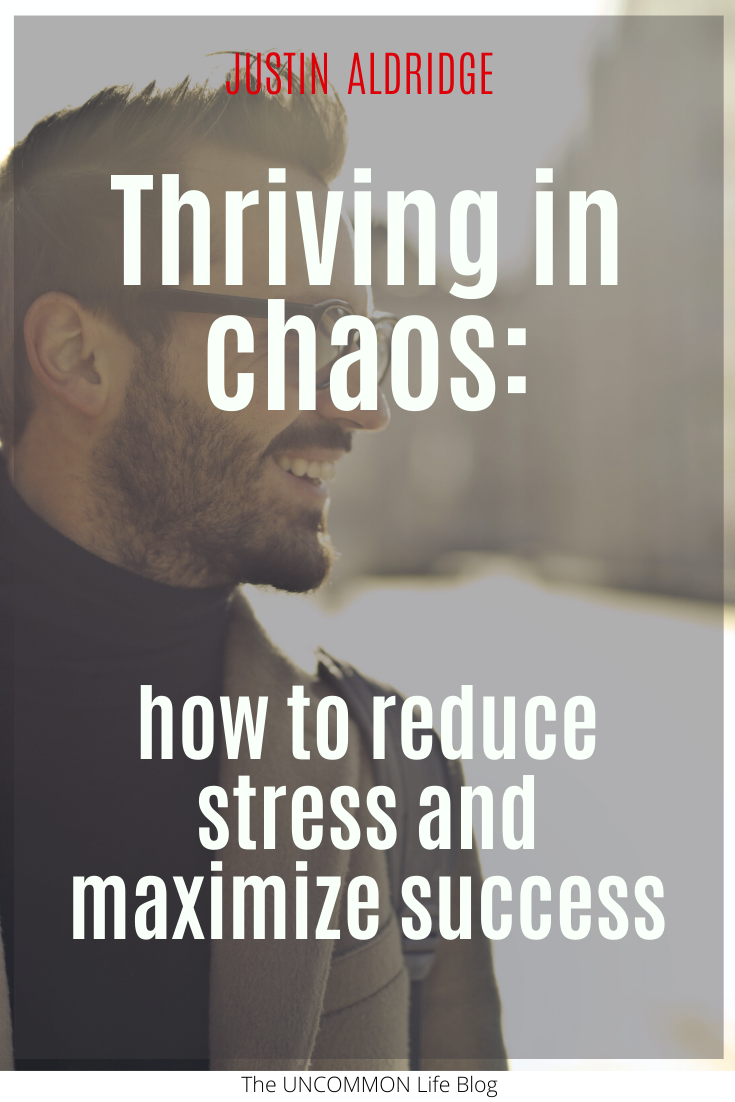 Man wearing glasses looking off to the right smiling in the background behind the text, "Thriving in chaos: how to reduce stress and maximize success" in white font.