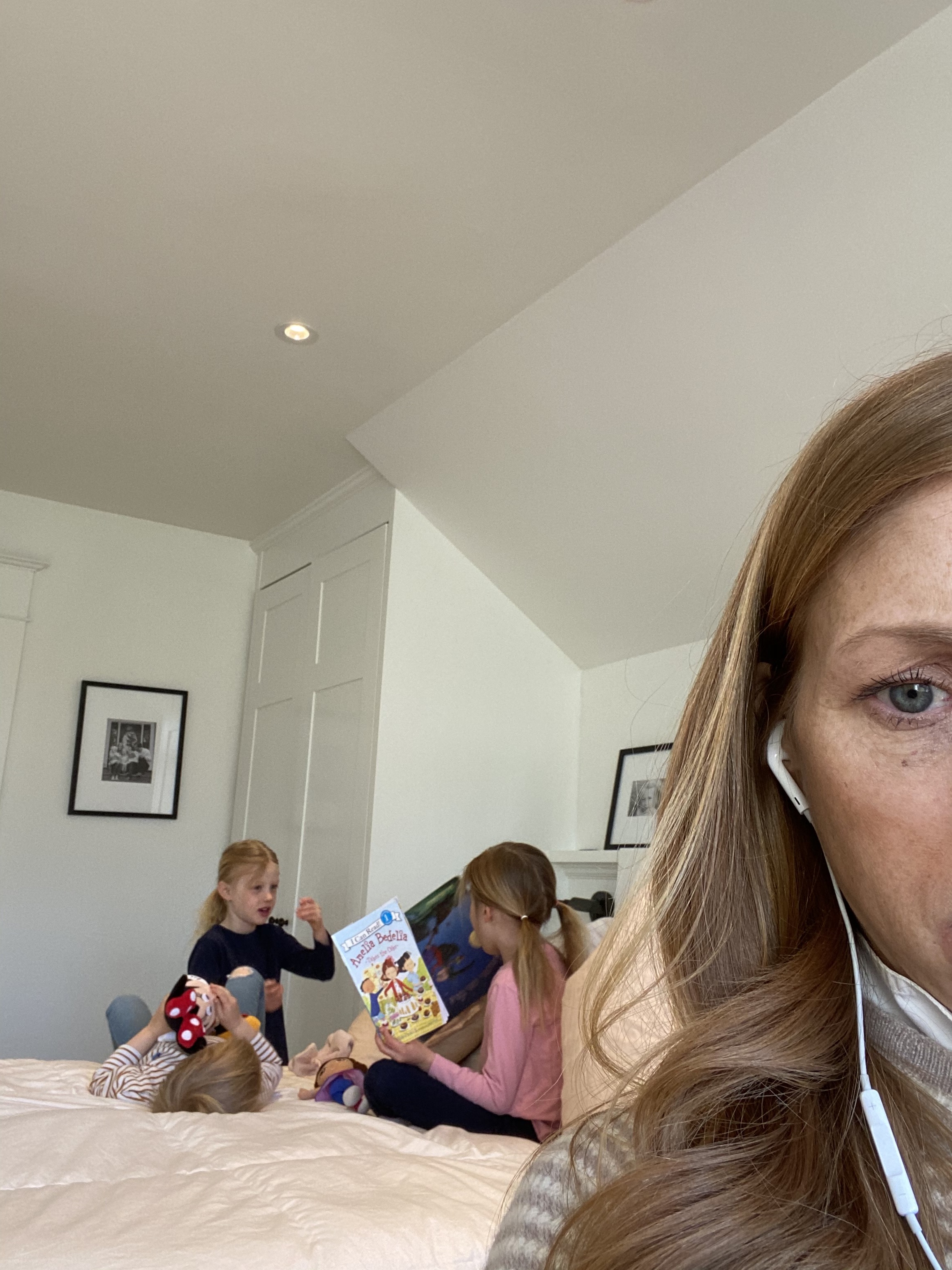 Martha Switzer on a conference call while three children play in the background