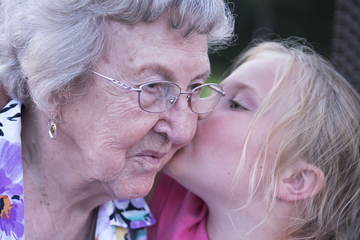 grandma with great granddaughter giving her a kiss on the cheek