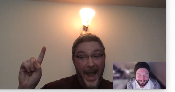Zoom video chat between two men with one man smiling and pointing to a lightbulb above his head