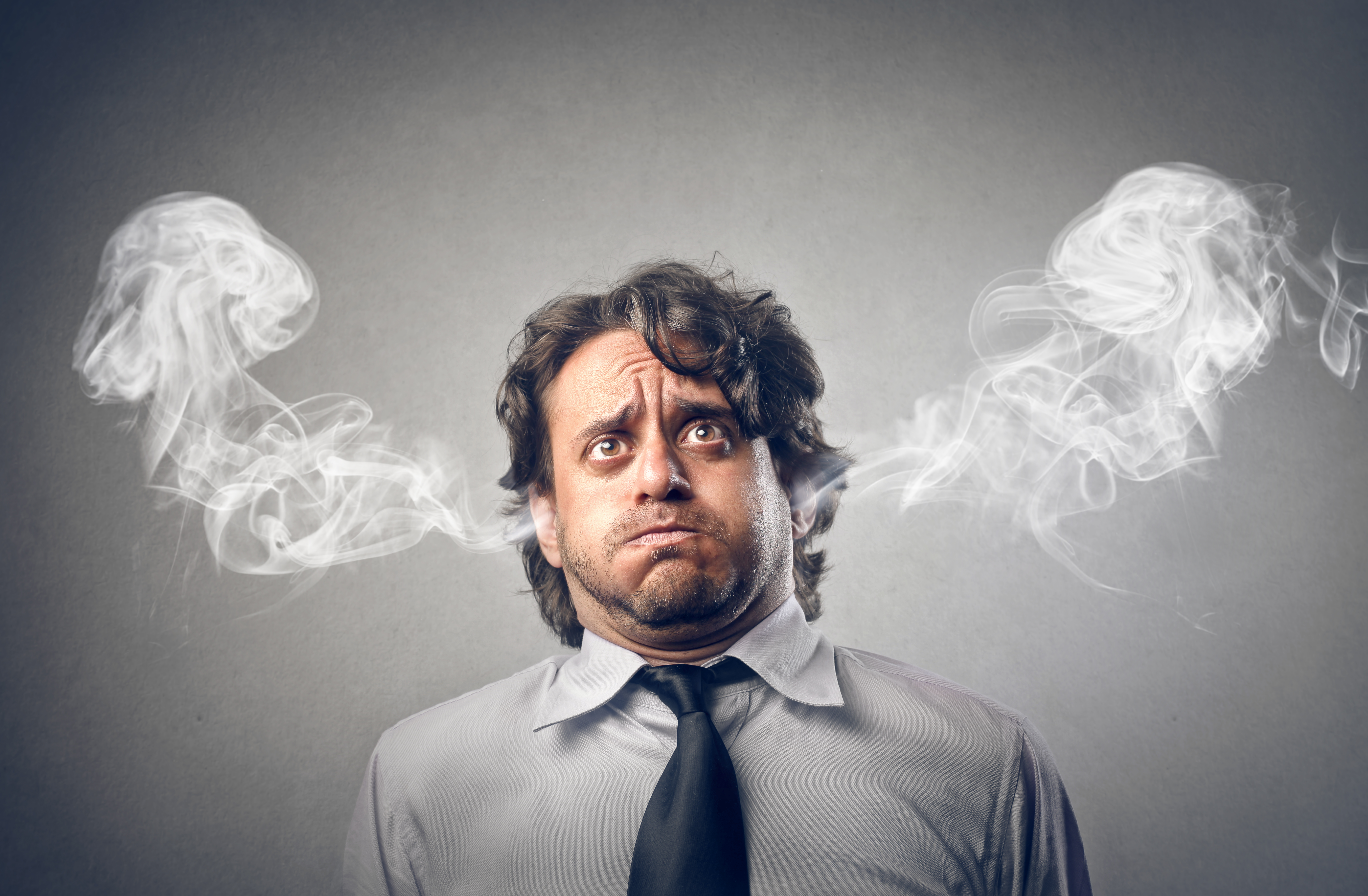 Photo of a stressed man with smoke coming out of his ears
