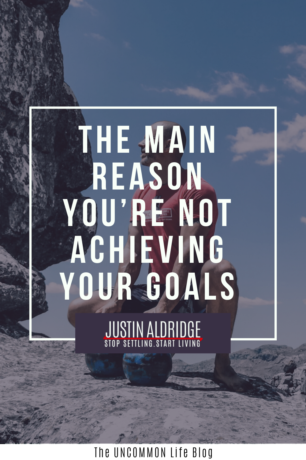 Man on a cliff squatting down in the background behind the text, "The main reason you're not achieving your goals" in white font.