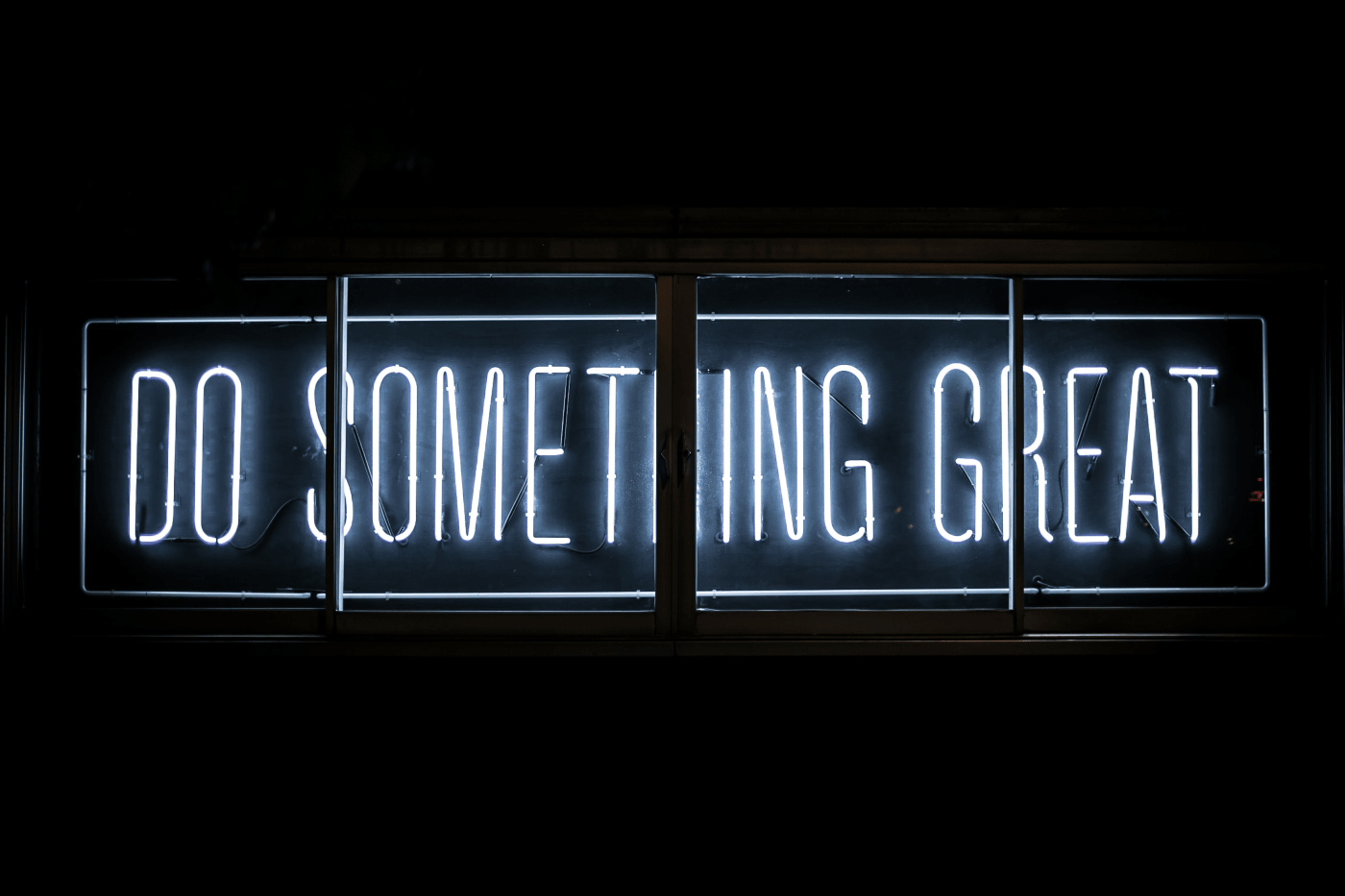 "DO SOMETHING GREAT" neon sign in black background | The magic of setting unrealistic goals in midlife