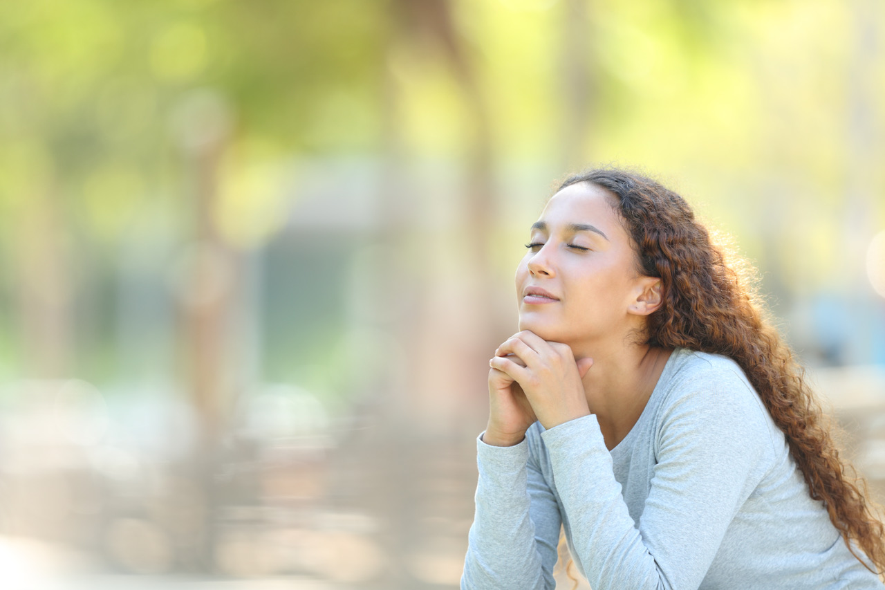 Mixed-race woman relaxing meditating in a park