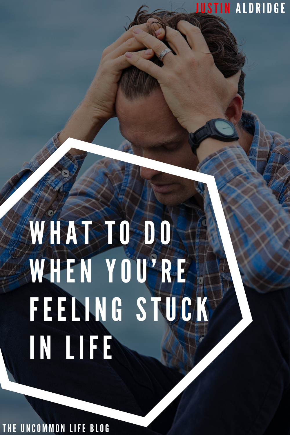 Man sitting down holding his head and staring at the ground behind the text, “What to do when you’re feeling stuck in life” in white font
