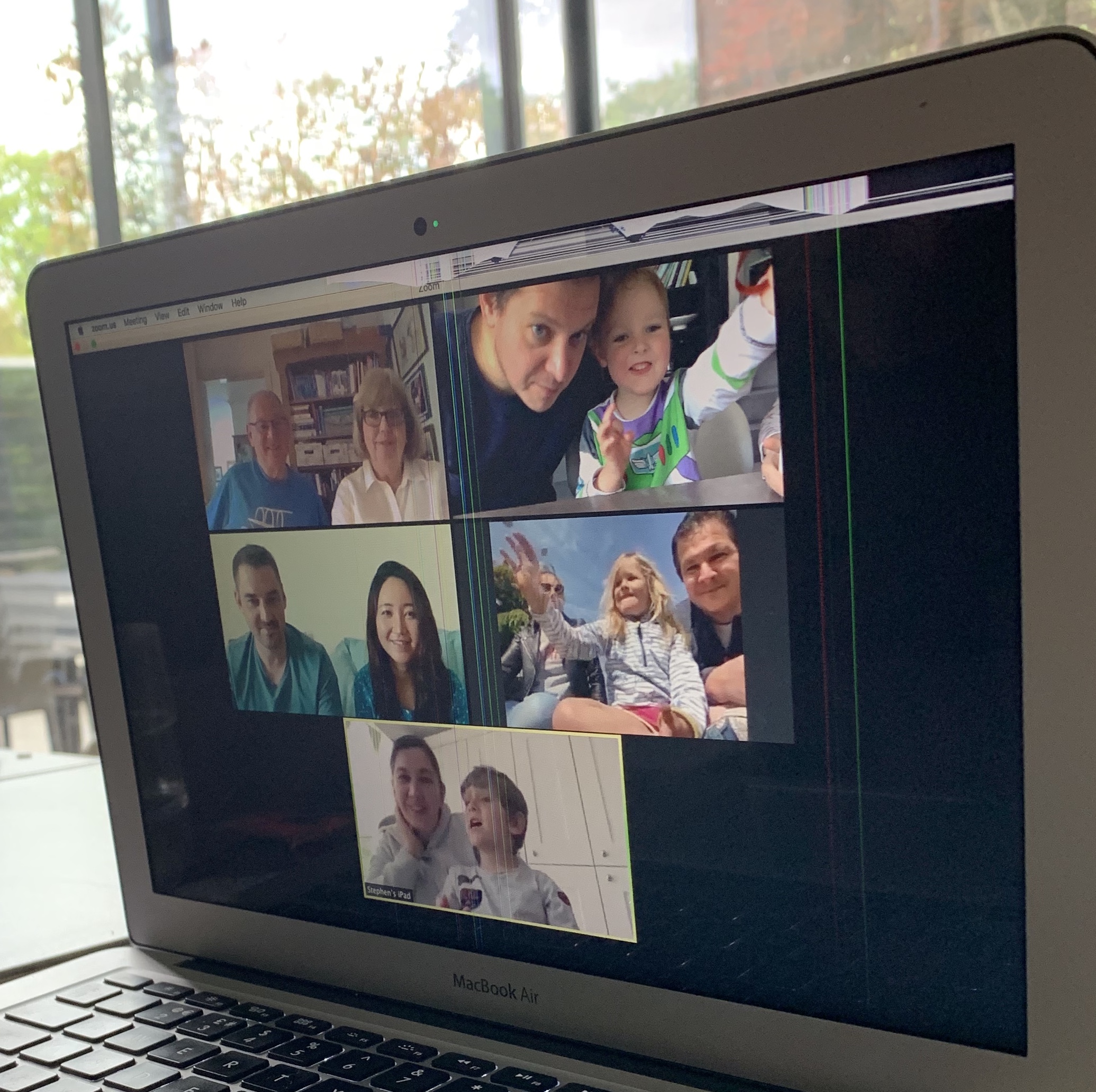 Laptop computer screen showing a family having a zoom call
