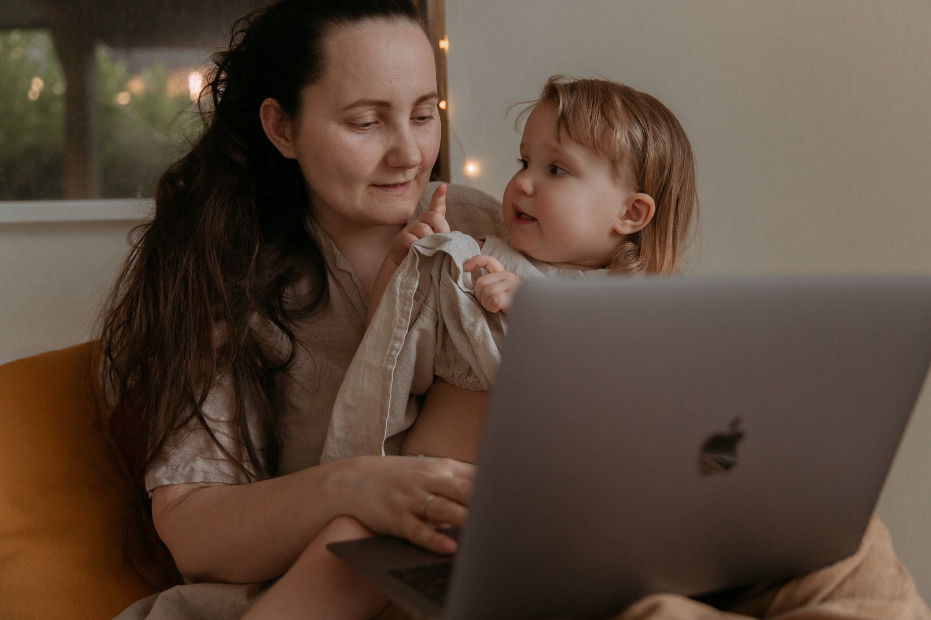 Mom working on her laptop and holding her baby