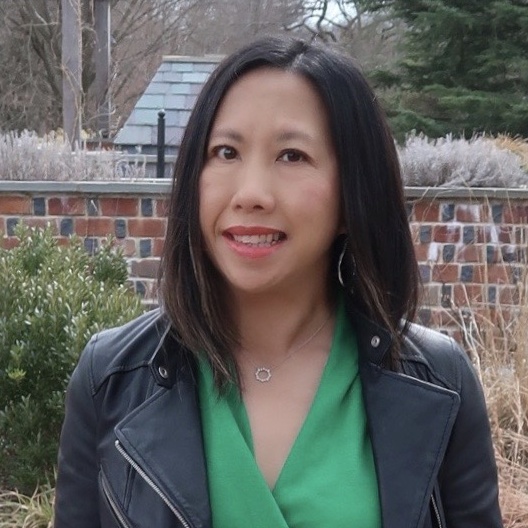 Donna is an Asian woman wearing a black leather jacket and green top