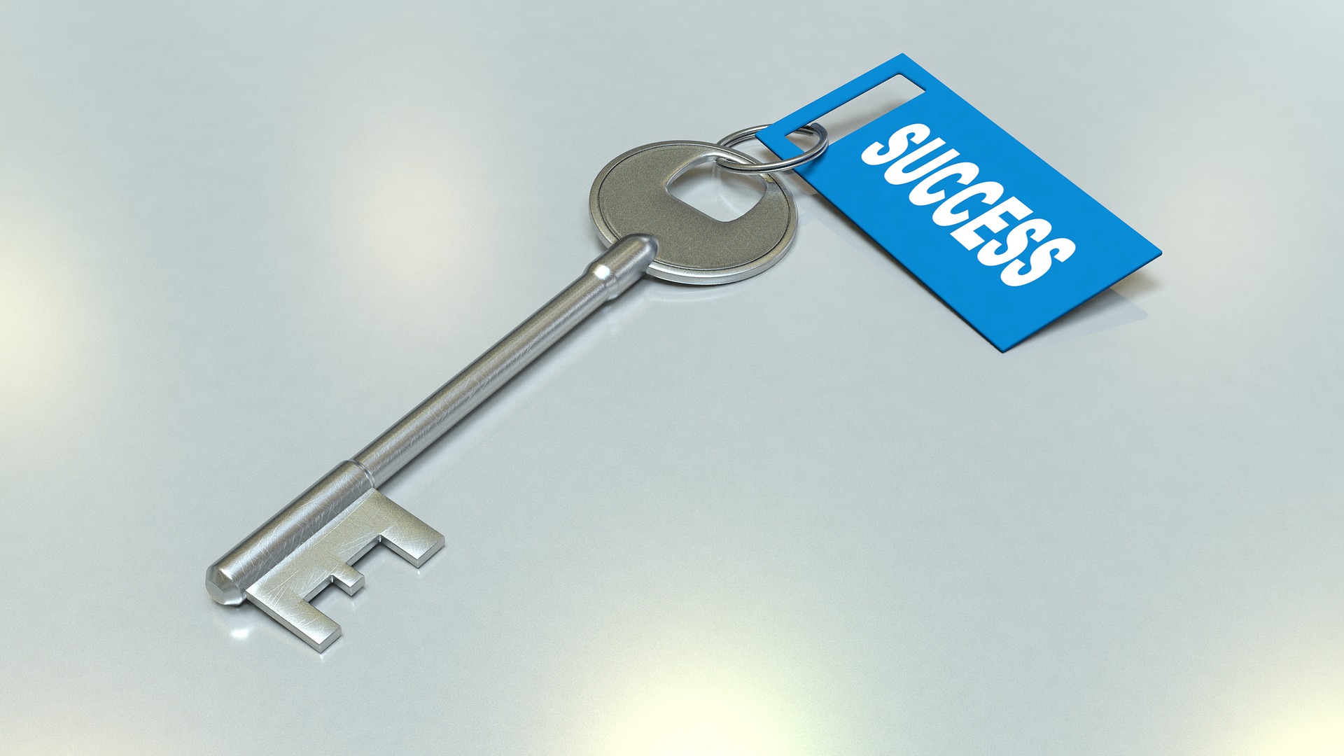A silver key with a tag saying “Success”