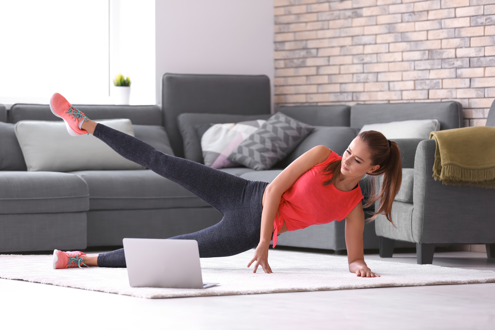 young woman doing exercises at home during quarantine