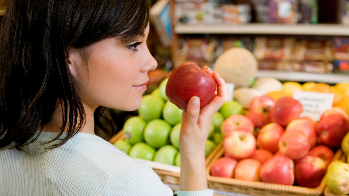 woman grocery shopping for apples