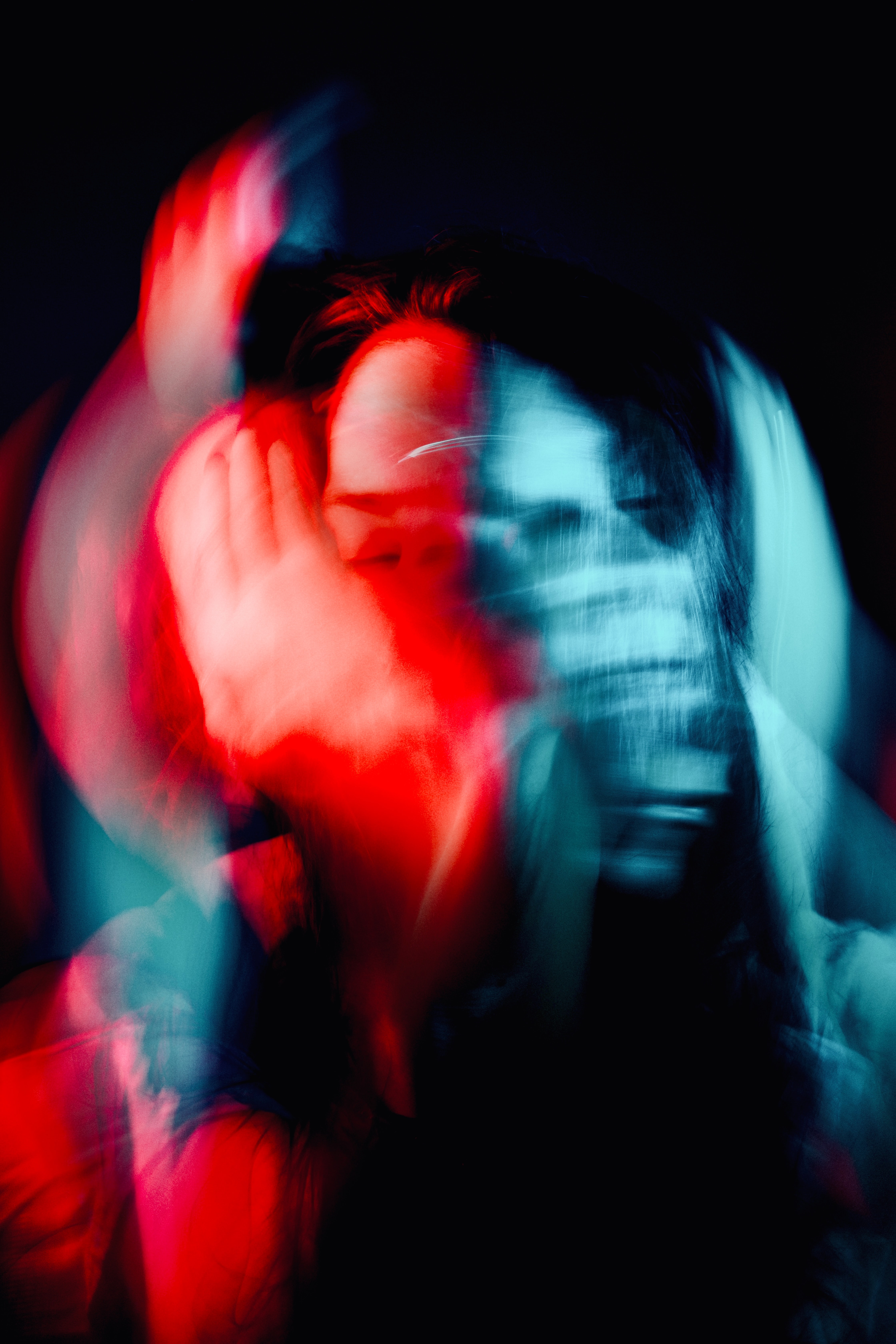Abstract, diptych image of a woman in red and blue light