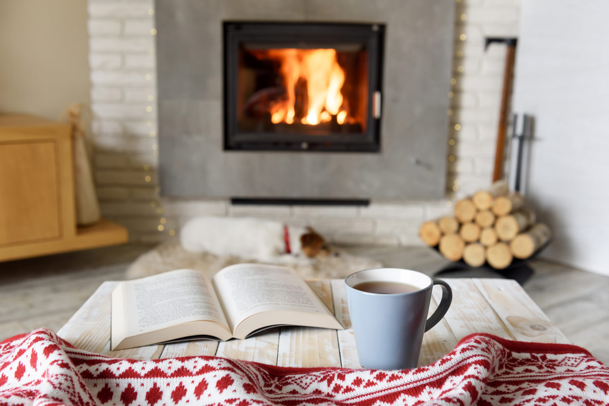 Creating a cozy space to get through the winter - a book and cocoa in front of a fire.