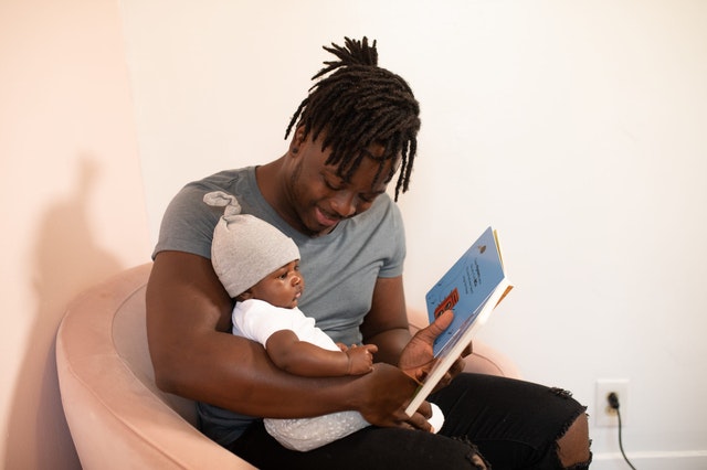 father-holding-baby-reading-book