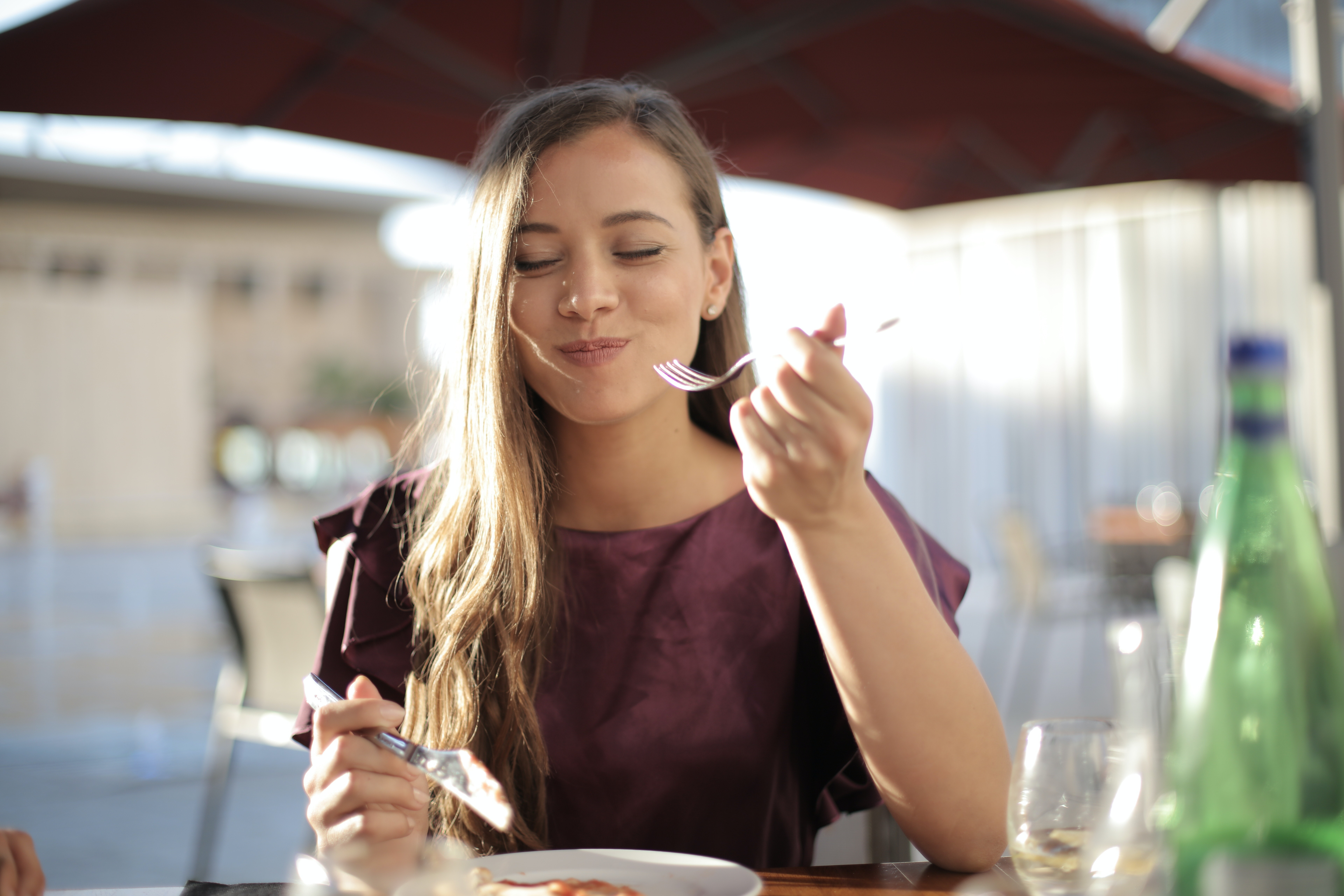 woman eating a meal outside and smiling