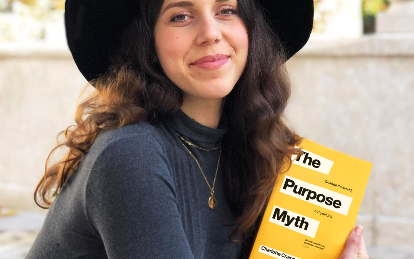 Charlotte Cramer, author of The Purpose Myth, holds book