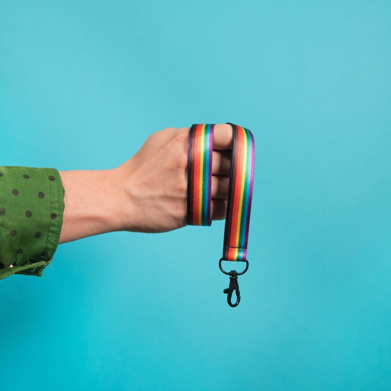 Person holding a rainbow lanyard