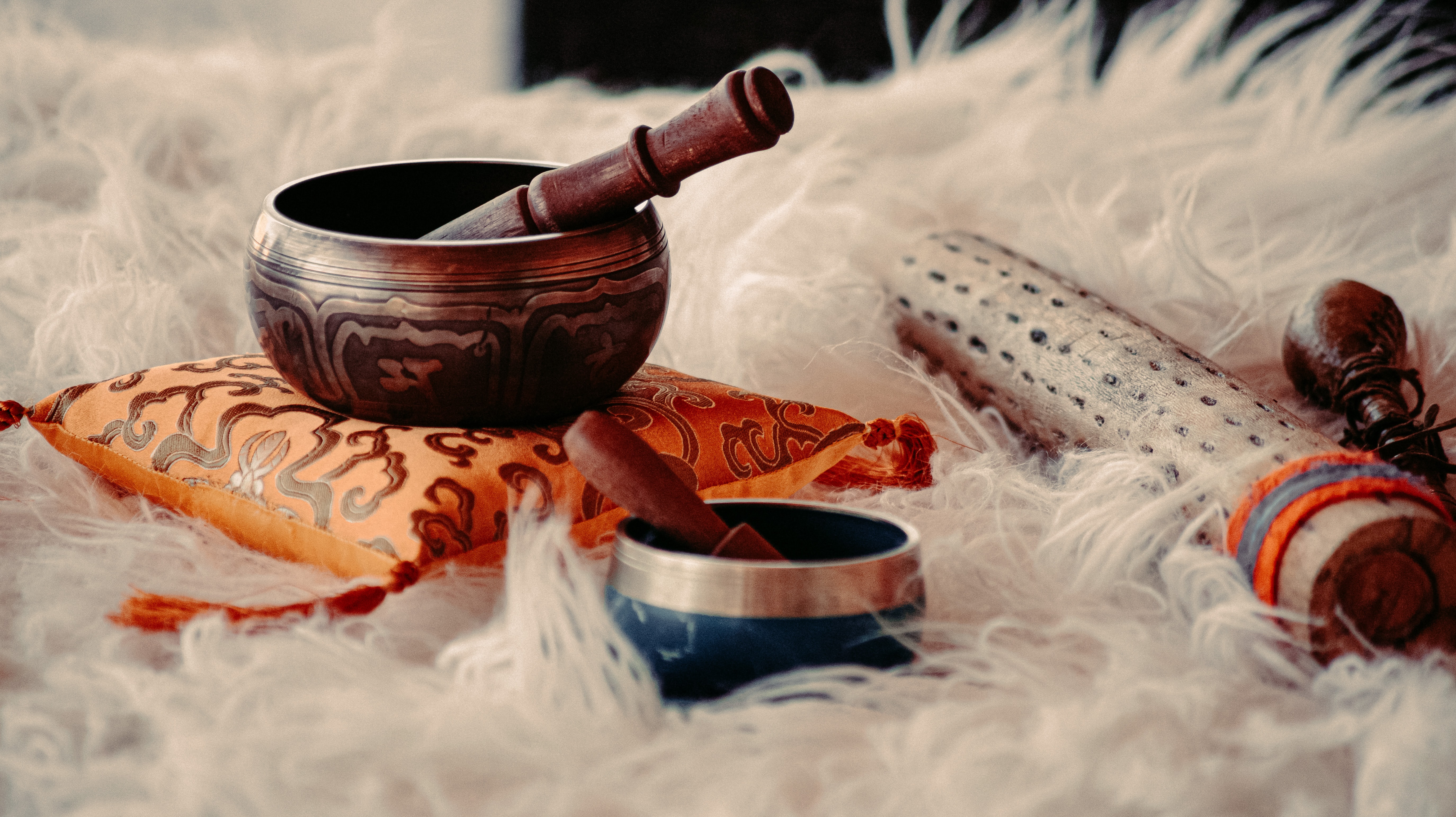 An image of Tibetan singing bowls and wind instruments on a sheepskin