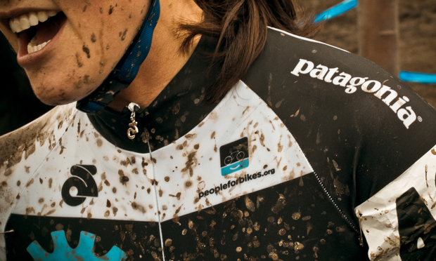 A cyclist wearing Patagonia clothing and splattered with mud
