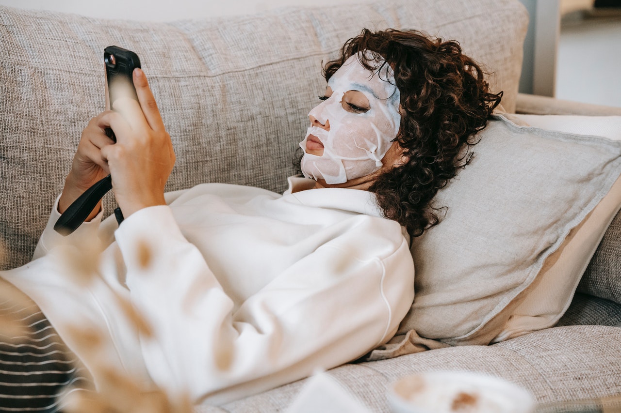 Woman wearing a face mask and holding a phone