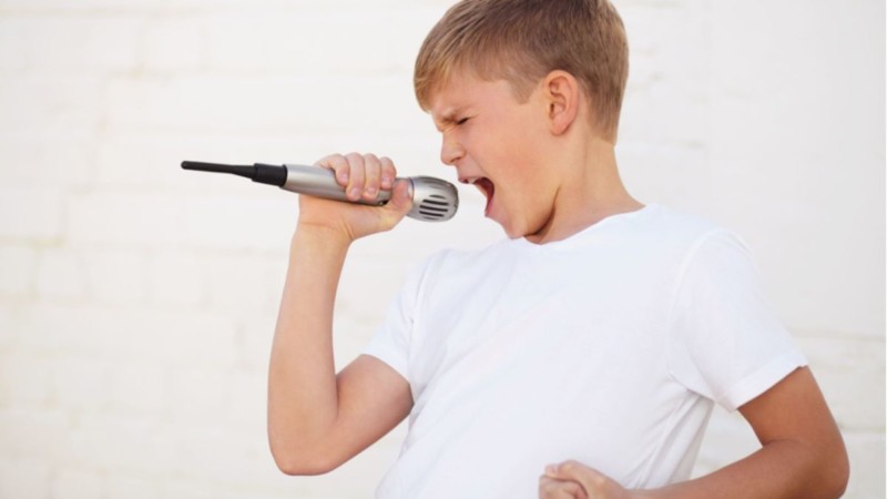 Kid singing with passion holding a mic