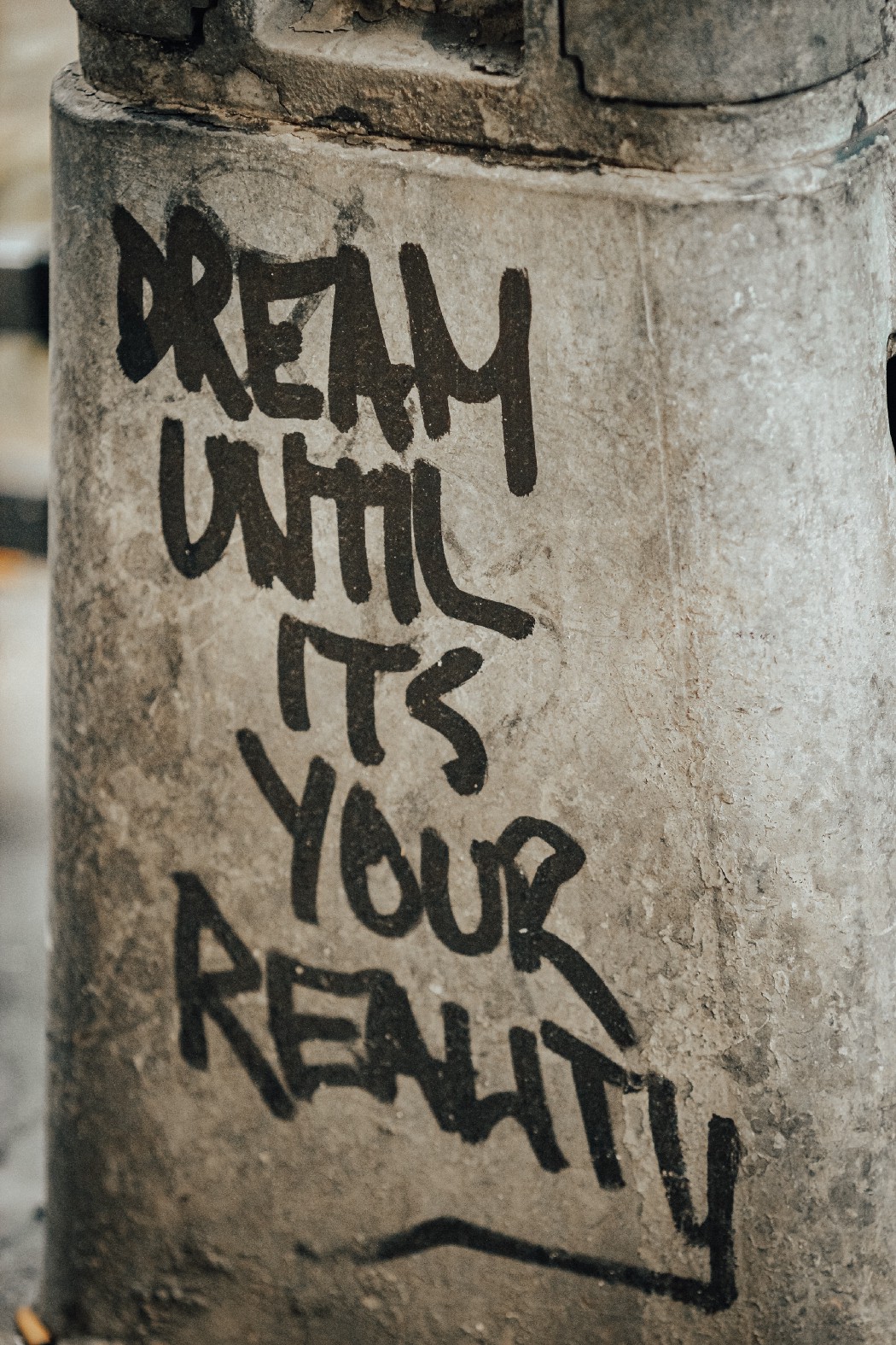 concrete slab with writing that says dream until it's your reality 