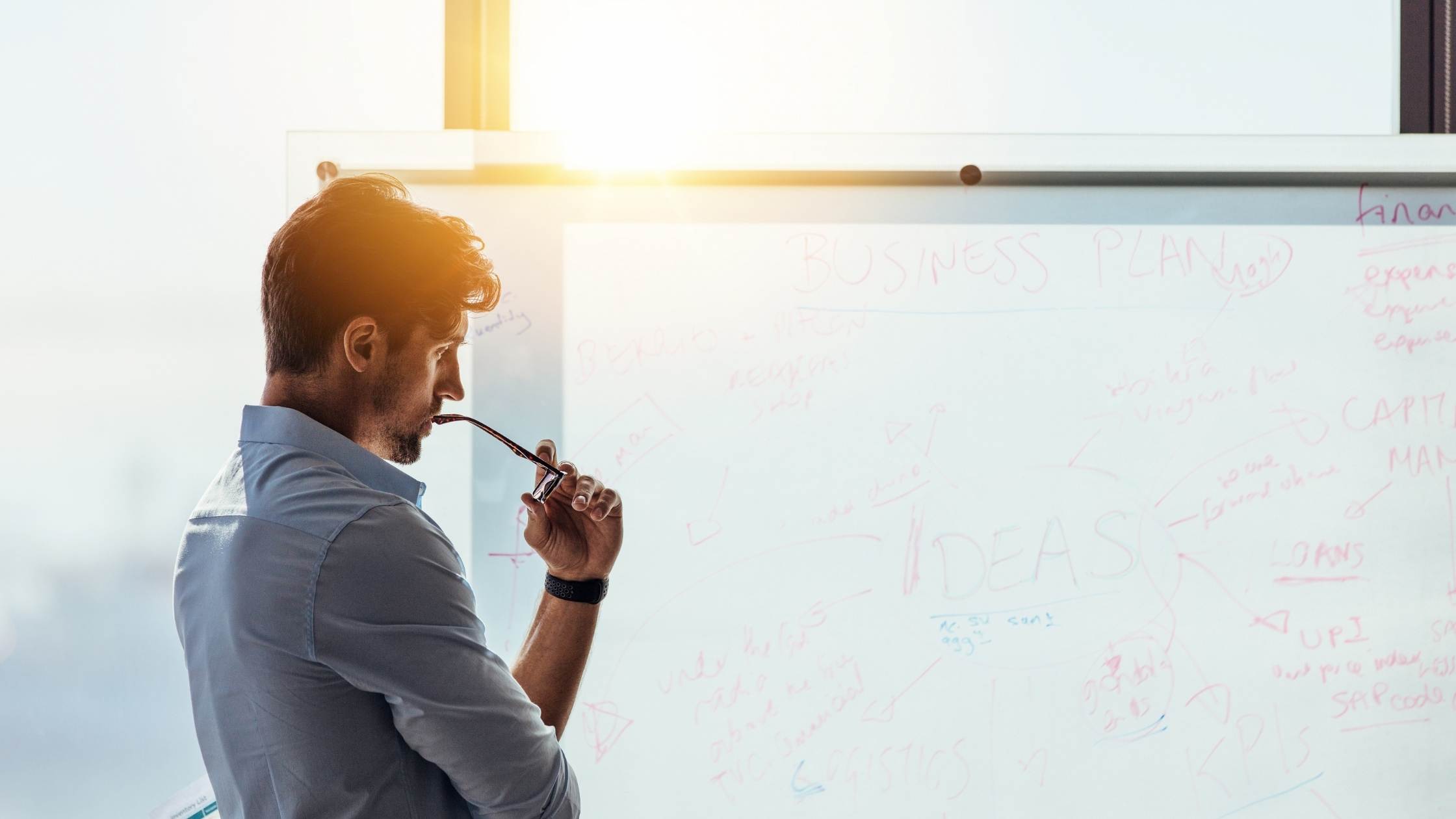Entrepreneur putting down business ideas on white board