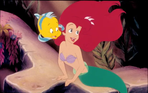 Flounder whispers in Ariel's ear in a scene from The Little Mermaid