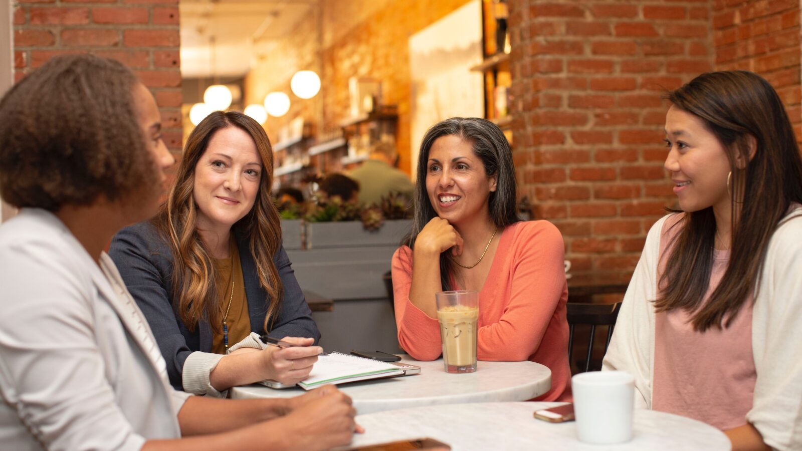 Four women working in a business meeting in a cafe coffee shop