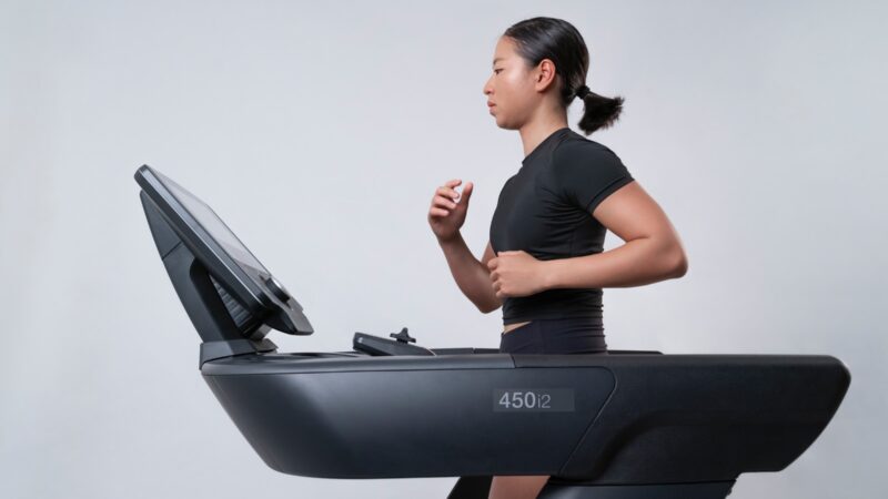 Side view of fit, young woman running on a treadmill.