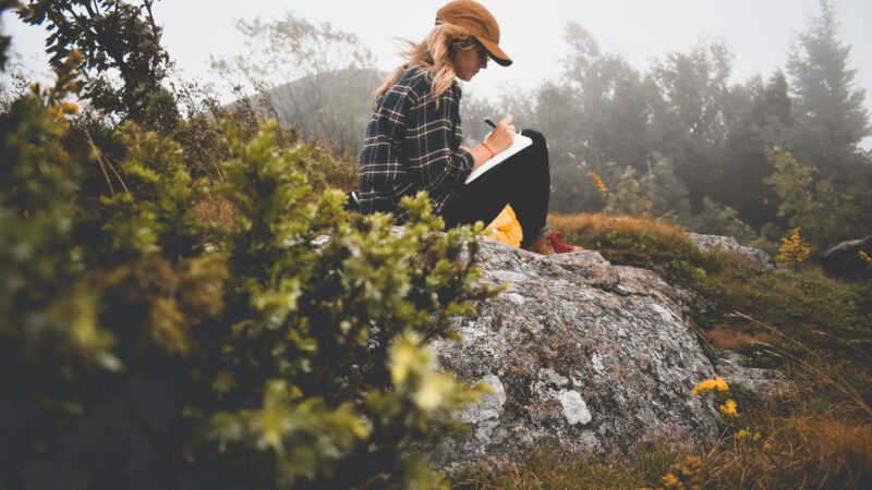 woman outdoors journaling