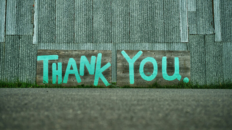 Cool graphic "Thank you" graffiti painted in green on the outside of a building.