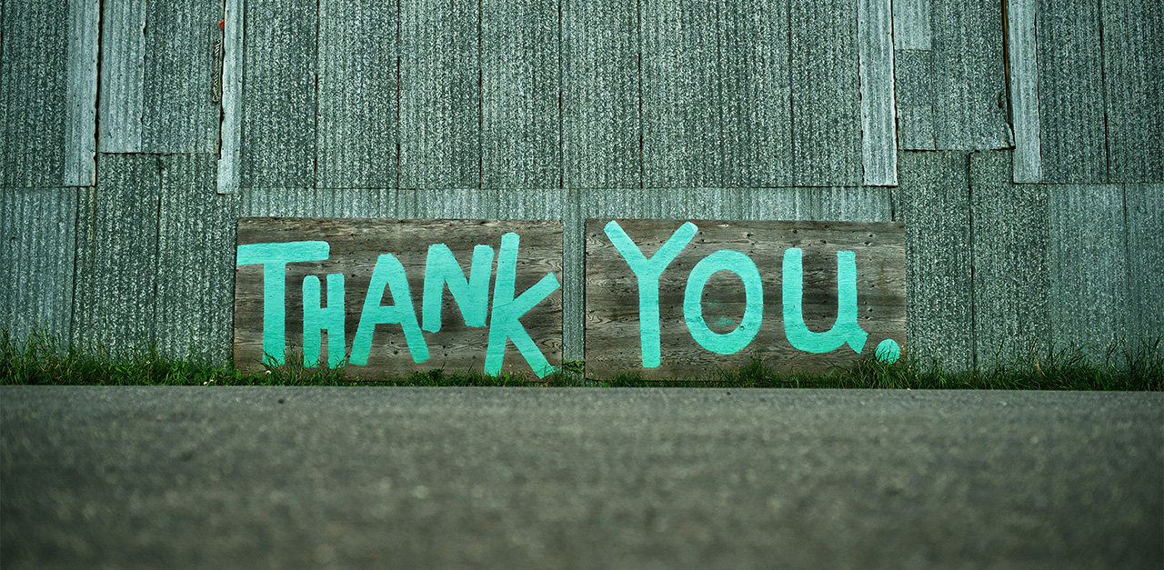 Cool graphic "Thank you" graffiti painted in green on the outside of a building.