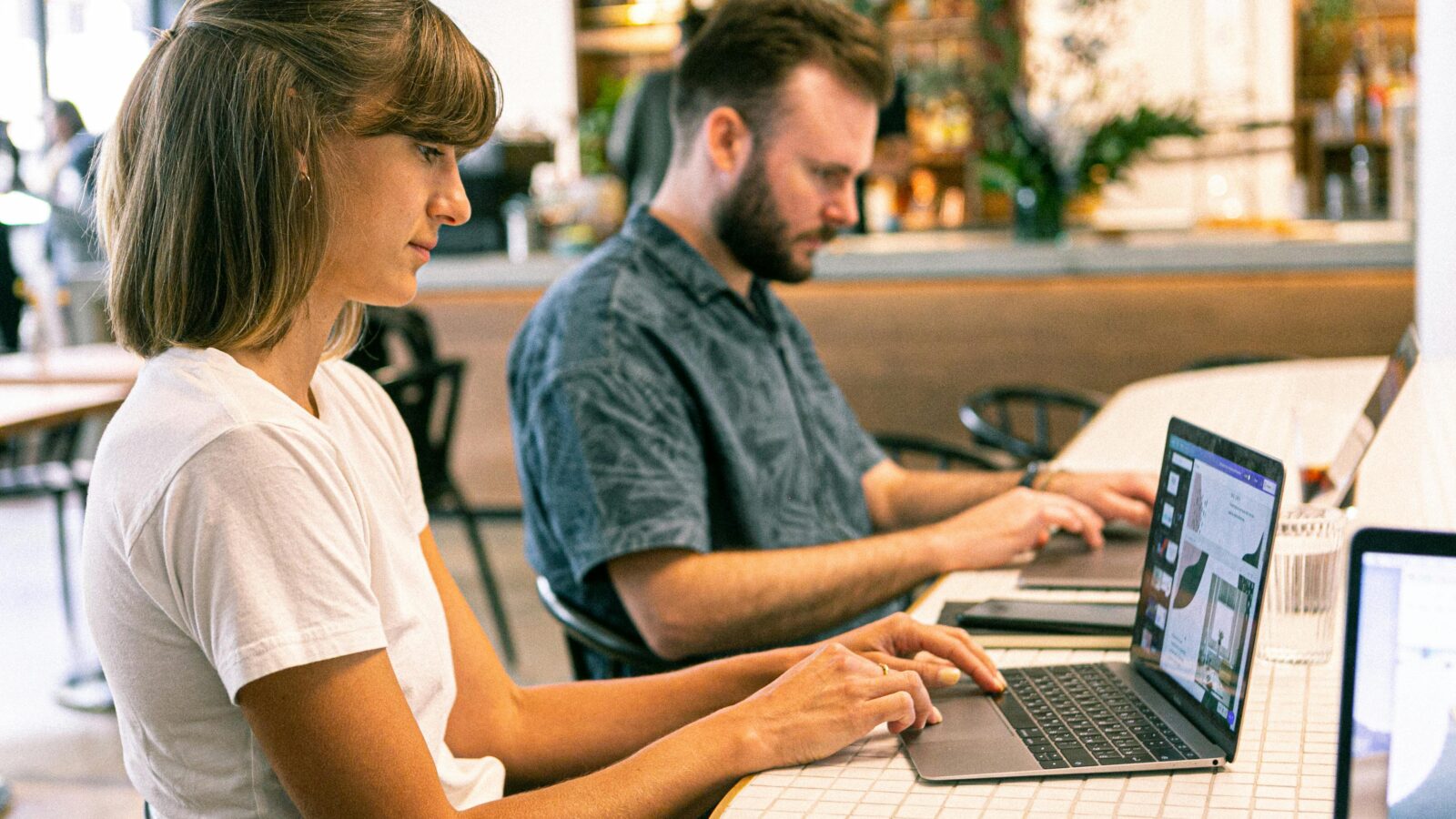 Two young workers typing on a laptop